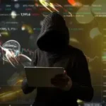 Usuario desconocido con gabardina negra utilizando una laptop.