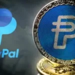 Logo convencional de Paypal y de una moneda fisica sobre la misma empresa.