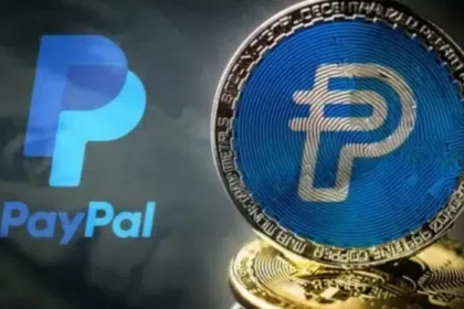 Logo convencional de Paypal y de una moneda fisica sobre la misma empresa.